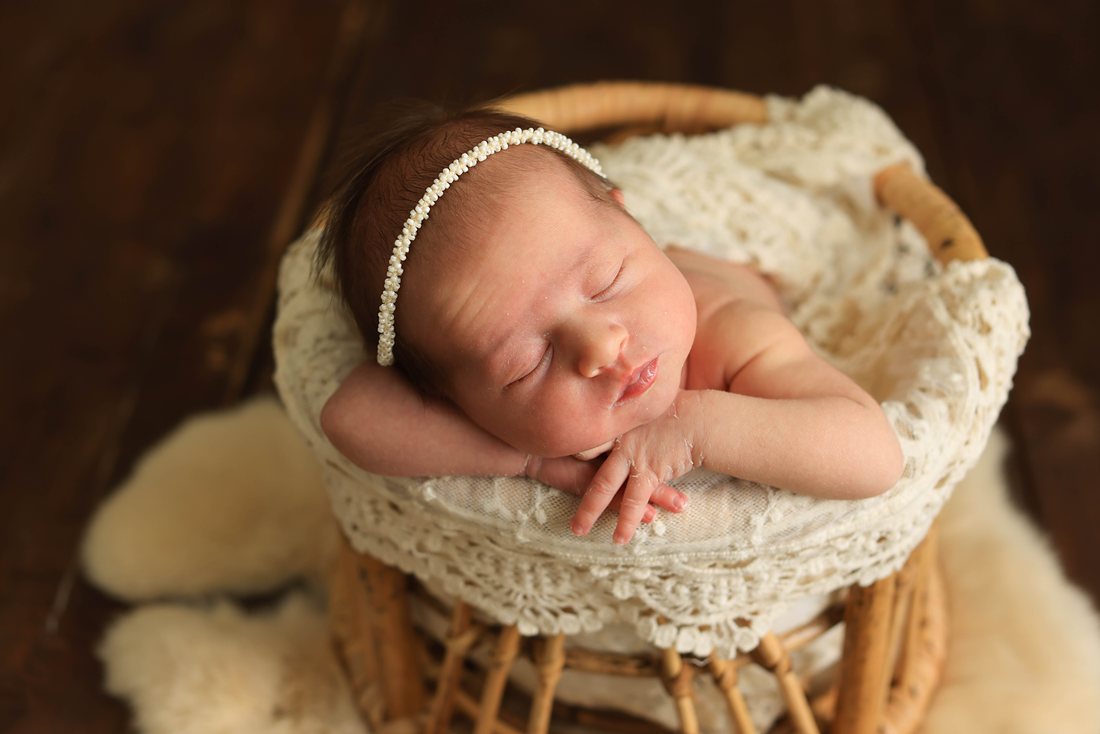 Newborn baby sleeping in a wicker basket — newborn photography Dubai